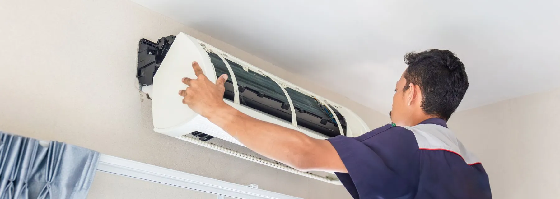 Monteur installeert een airconditioning binnenunit aan het plafond