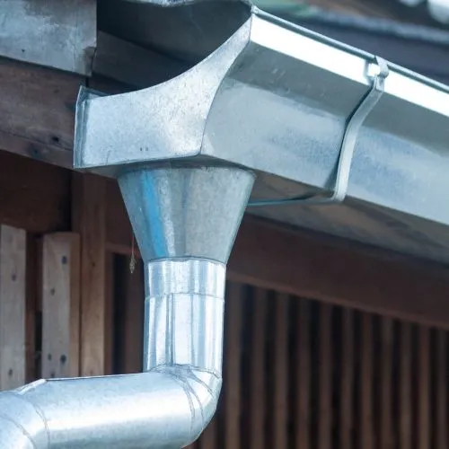 Detail van een zinken dakgoot en regenpijp